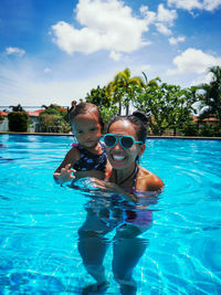 Portrait of mother and little daughter in swimming pool