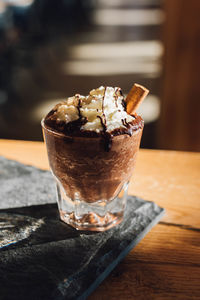 Hot drinking chocolate topped with whipped cream, chocolate drizzle, and cinnamon in cafe