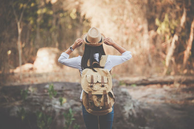 Rear view of woman wearing hat standing on land