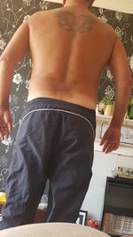 Rear view of man standing at home