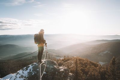 Woman standing on mountain against sky