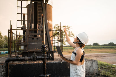  asian woman with safety helmet standing in oil refinery structure petrochemical industry.