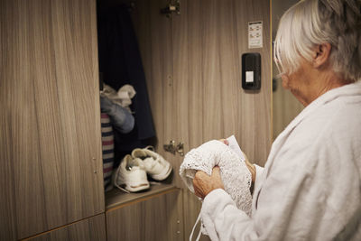 Woman putting clothes into locker