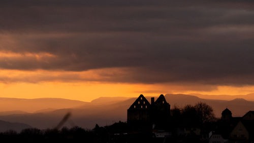 Silhouette buildings against sky during sunset