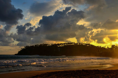 Scenic view of beach against sky during sunset