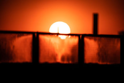 Close-up of illuminated lamp at sunset