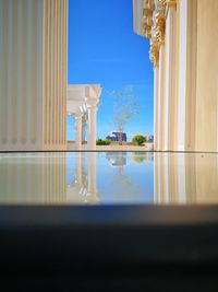 Reflection of building in water against clear sky