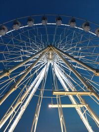 Low angle view of ferris wheel against clear blue sky