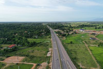 High angle view of road amidst field against sky