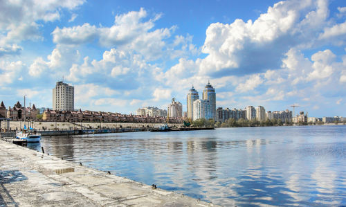 Sea by buildings against sky in city