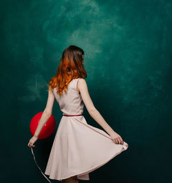 Rear view of woman standing against red background