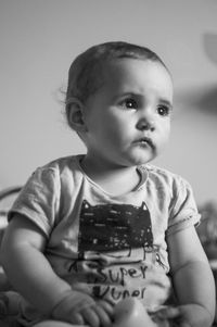 Portrait of cute baby girl sitting at home