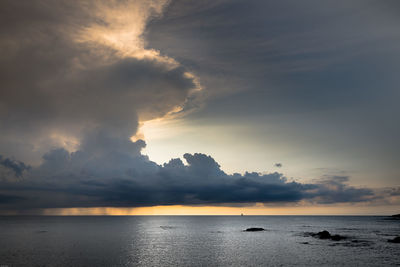 Scenic view of sea against cloudy sky during sunset