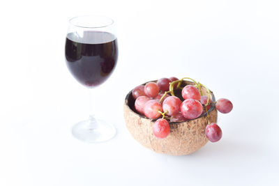 Close-up of grapes in glass against white background