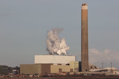 Smoke stack against sky in city