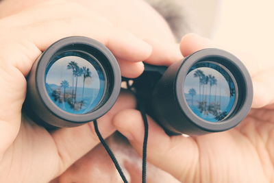 Close-up of man looking through binoculars