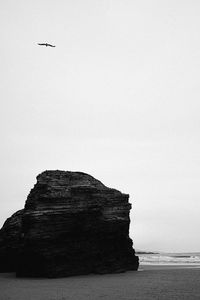 Low angle view of rock formation in sea against clear sky