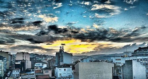 Buildings against cloudy sky at sunset