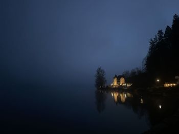 Bridge over river against sky at night