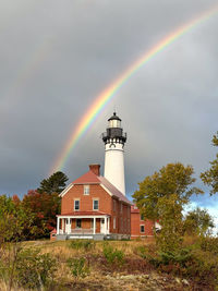 Lighthouse by sea against sky