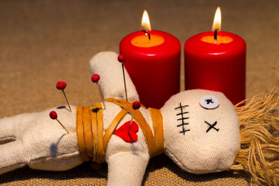 Close-up of spooky doll with illuminated candles