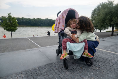 View of mother and daughter relaxing on the banks of the river danube in the city of bratislava.