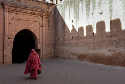 Rear view of woman walking in tunnel