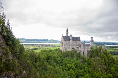 Buildings in city against cloudy sky