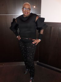 Young man wearing mask standing against wall