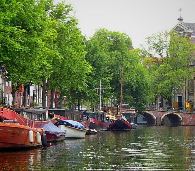 water, tree, transportation, nautical vessel, waterfront, mode of transport, boat, built structure, architecture, canal, river, building exterior, reflection, moored, lake, connection, bridge - man made structure, nature, day, sky