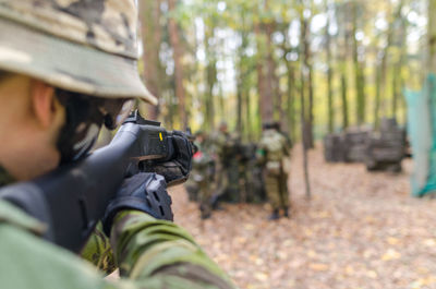 Soldier aiming with gun at forest