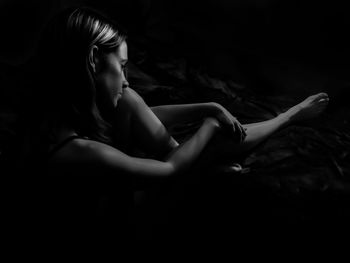 Woman sitting in darkroom