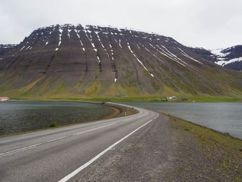 Road by mountain against sky