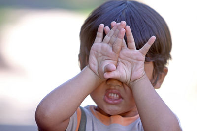 Close-up of boy covering eyes