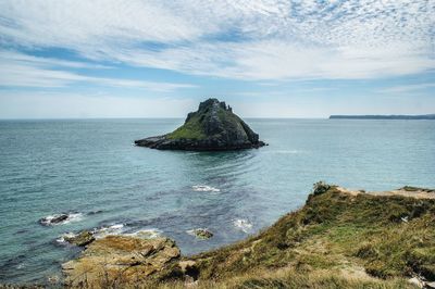 Scenic view of rock formation in sea against sky