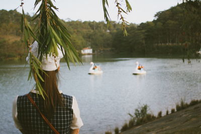 Rear view of women standing by lake