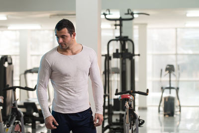 Muscular man standing in gym