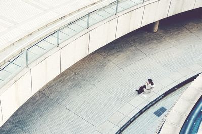 High angle view of woman sitting on retaining wall