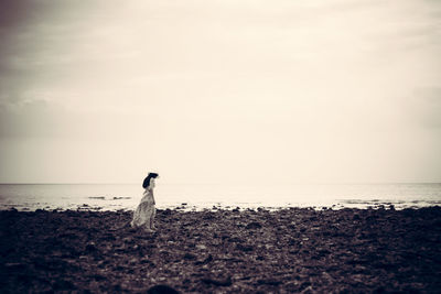 Depression concept black and white young woman standing alone on beach