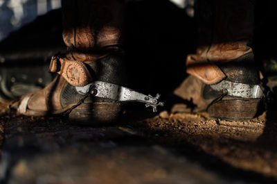 Close-up of shoes on dirt road