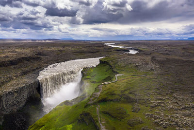 Scenic view of waterfall against sky