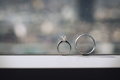 Close-up of wedding rings on glass table