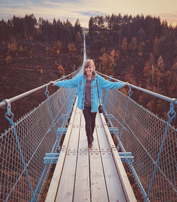 Rear view of woman walking on footbridge