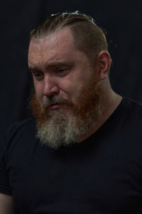 Side view of man looking away against black background