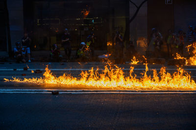 Group of people on fire in city at night