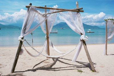 Clothes drying on beach against sky