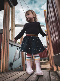 Rear view of woman standing on railing