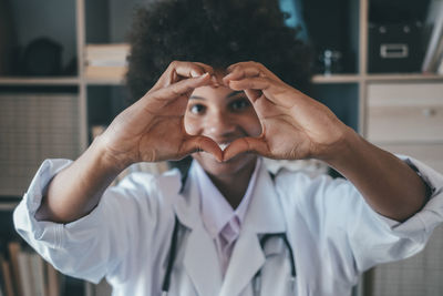 Doctor making heart gesture in clinic