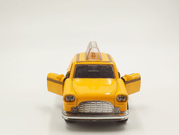 Close-up of yellow toy car against white background