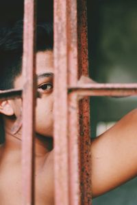 Portrait of young man looking through window